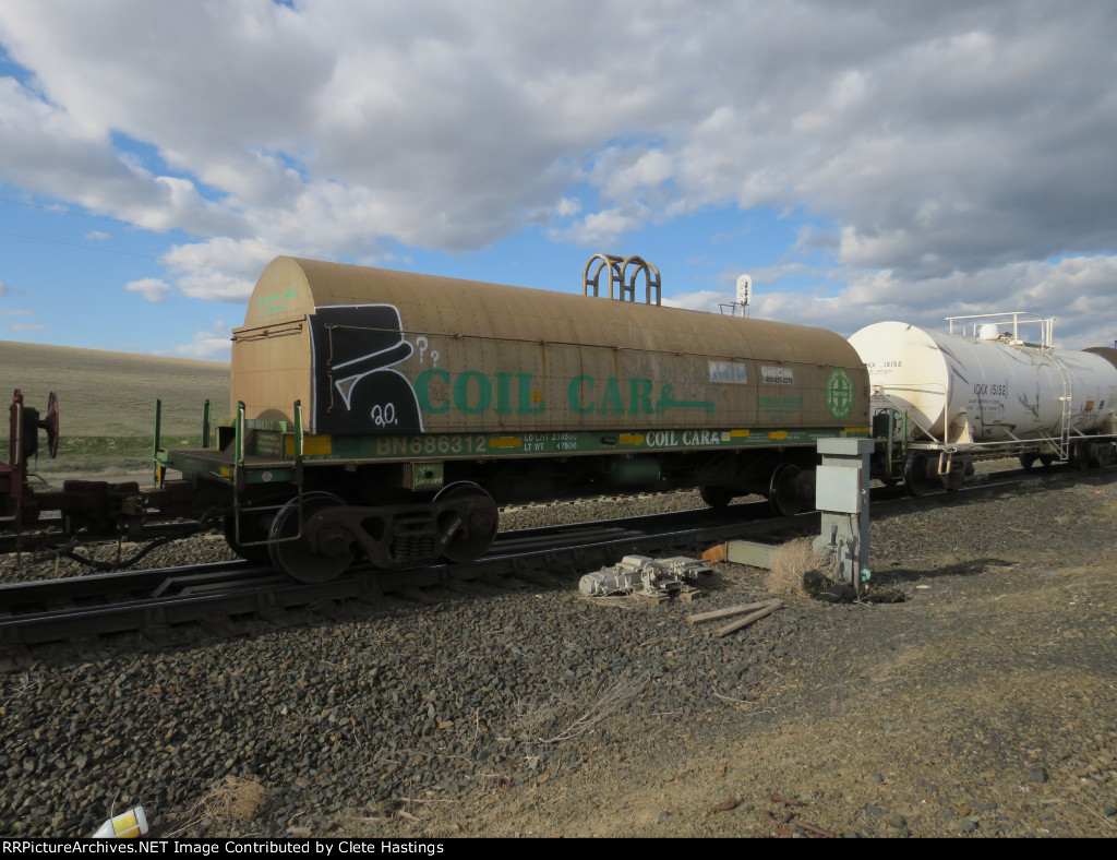 BN coil car with an interesting BNSF cascade green cover.